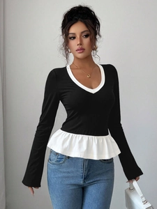 Top peplum de manga larga en contraste blanco y negro con cuello redondo ajustado