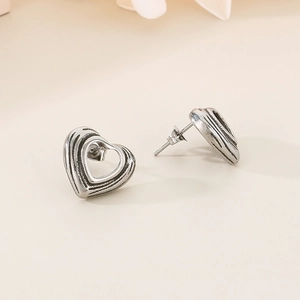 Macro shot of vintage silver hollow heart-shaped earrings with textured metallic finish