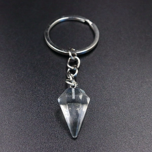 Macro shot of a clear hexagonal crystal point pendant on a silver keychain with link chain