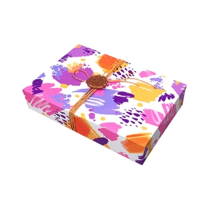 Minimalist colorful graffiti gift box with twine and bronze wax seal on white background