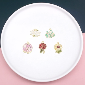 Detail of five enamel flower charms including rose and sunflower for DIY jewelry making