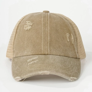 Detailed macro view of distressed washed cotton fabric and mesh on khaki trucker cap