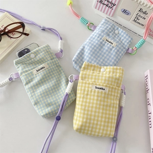 Close-up of yellow and blue plaid cotton phone pouches with adjustable rope straps