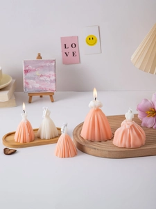 Detail shot of wedding dress scented candles in pink and white on a wooden tray