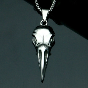 Macro detail of silver eagle skull pendant showing sharp beak and metallic texture
