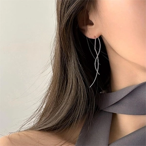 Detail of silver long wave threader earrings showing minimalist curved design on model