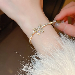 Elegant gold butterfly zircon bracelet with adjustable chain on a model's wrist