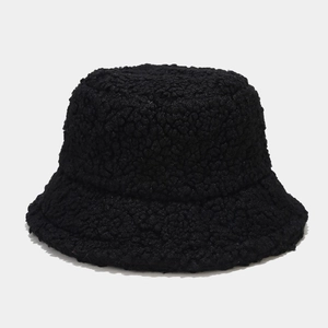 Macro view of plush lamb wool bucket hat showing thick curly faux fur texture in black