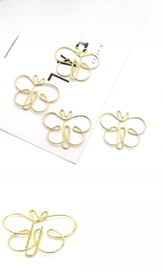 Detail showing butterfly shaped paper clips in gold and rose gold plated metal wire
