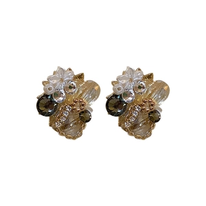 Vintage gold crystal flower earrings with white petals and clear rhinestones on white background