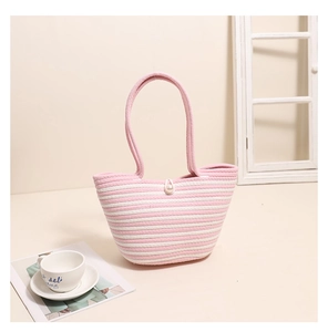 Detailed close-up of pink and white striped woven tote bag featuring an elegant pearl clasp