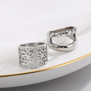 Geometrische ringen met bloem- en hartpatroon van gepolijst staal op een bordje