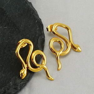 Elegant gold snake earrings in stainless steel on a textured grey background