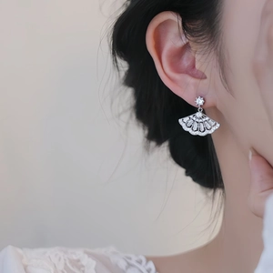 Elegant silver fan-shaped earrings with sparkling cubic zirconia worn by model
