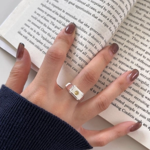 Detail of silver S925 ring with yellow gemstone on an open book background