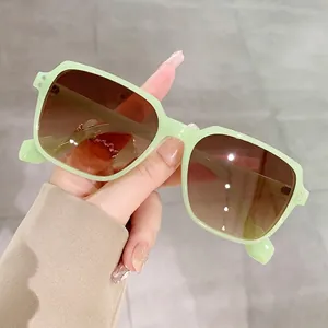 Square oversized mint green sunglasses with dark brown gradient lenses and rivet details