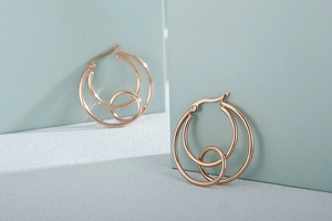 Detail of rose gold interlocking geometric hoop earrings with layered minimalist design