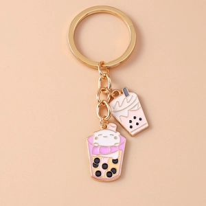 Detail of a pink boba tea keychain with a cute white bear charm and golden metal ring