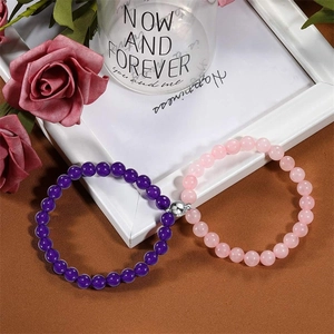 Detail of couple bracelets with magnetic attraction beads and purple natural stone