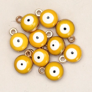 Macro detail of yellow evil eye charms with golden edges for jewelry making DIY