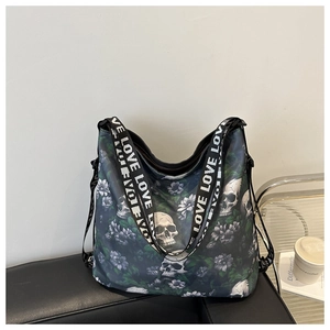 Close-up of nylon tote bag featuring skull floral print and LOVE lettered strap detail
