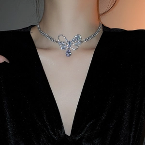 Macro view of crystal bow-knot pendant necklace with teardrop zircon on female neck