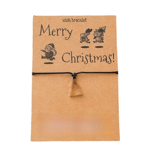 Christmas wish bracelet with silver tree charm and black cord on card packaging