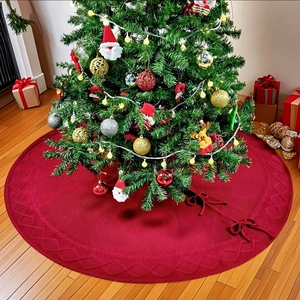 Détail du tapis de sapin de Noël rouge tricoté avec des motifs de torsades complexes