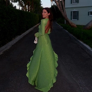 Détail de robe longue dos nu à paillettes vertes avec ourlet à volants et fini brillant