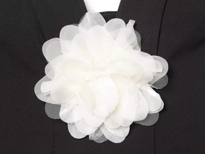 Détail d'une fleur 3D en résille blanche avec textures superposées sur un haut noir