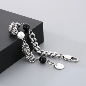 Titanium steel chain bracelet with black and white pearls on a jewelry gift box