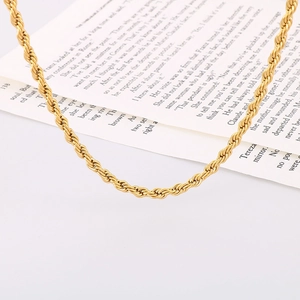 Detailed view of 18k gold plated rope chain necklace on vintage book paper background