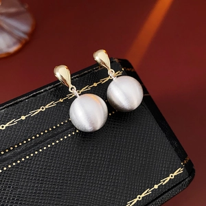 Vue macro de puces d'oreilles dorées et sphères argentées sur un coffret à bijoux noir