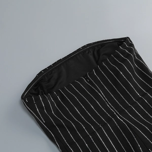 Detail of black tube mini dress with vertical rhinestone stripes and metal zipper