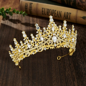 Detailed view of a gold bridal crown with crystals on a vintage wooden surface