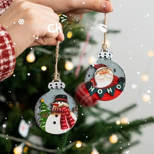 Wooden Christmas ornaments with Santa and Snowman hanging on a festive tree branch