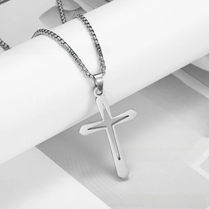 Detailed close-up of a hollow silver stainless steel cross pendant with a sleek box chain