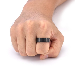 Close-up of 8mm men's black spinner ring with matte brushed surface and polished edges