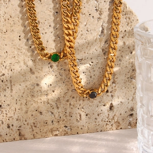 Detail of 18K gold-plated Cuban link necklace featuring a round green zircon stone