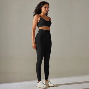 Close-up of seamless high-waist leggings and cross-back sports bra set in black knit