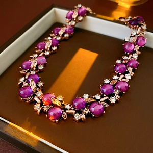 Detail view of vintage leaf necklace featuring purple gemstones and sparkling rhinestones