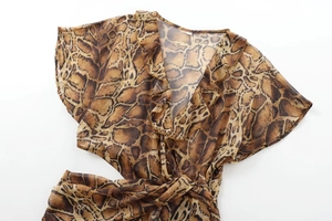 Detail of snake print midi dress showing ruffled V-neckline and tiered layering detail