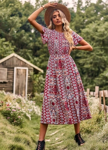 Détail de la robe bohème rouge à manches courtes et taille ajustée dans un cadre champêtre