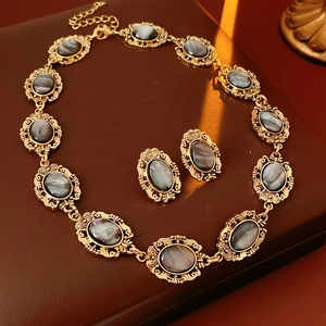 Detailed view of vintage gold-tone resin oval jewelry set with intricate carvings