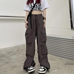 Detailed shot of dark grey cargo pants featuring functional large side pockets and elastic waist