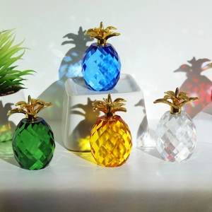 Detailed view of faceted crystal pineapples in four colors with gold metal leaves