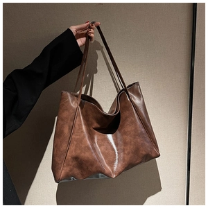 Close-up of brown soft leather tote bag showing large capacity and oiled texture detail