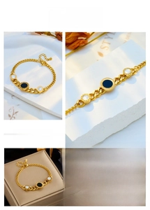 Detail of gold chain bracelet featuring Roman numeral circular charms with shell inlays