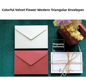 Detailed texture of velvet paper envelopes in white and wine red with rustic hemp rope