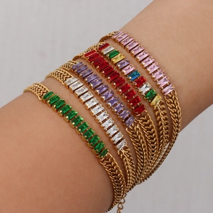 Bracelets dorés superposés avec pierres en zircone rectangulaires colorées sur poignet